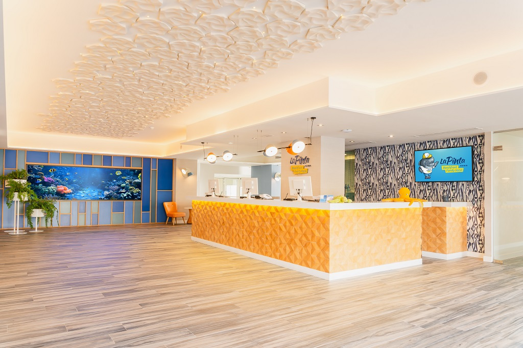 Recepción de hotel La Pinta en Tenerife con acuario y mostrador iluminado.