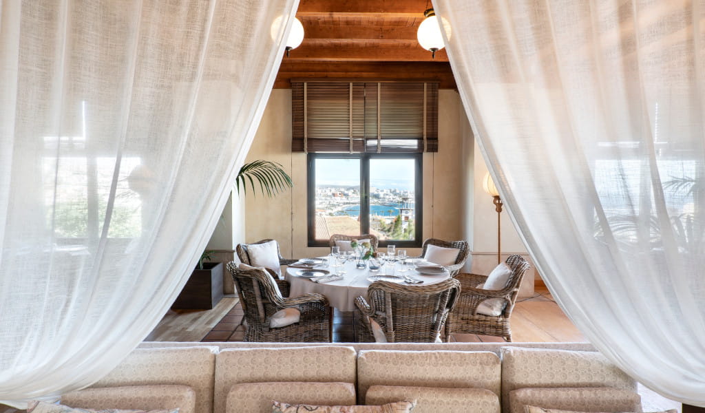 Comedor con vista al mar en Tenerife, decorado con cortinas blancas.