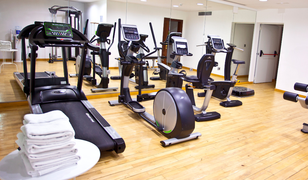 Gimnasio con bicicletas, caminadora y toallas en hotel de Tenerife.