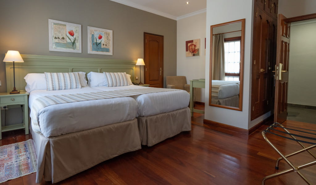 Habitación doble con cama grande, lámparas y espejo en hotel de Tenerife.