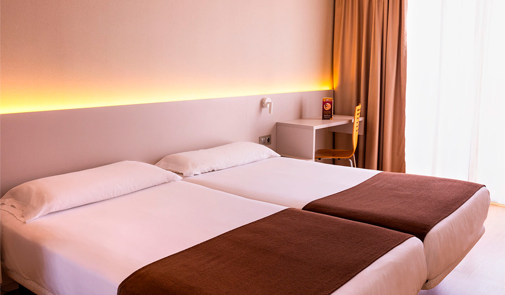 Cama doble en habitación de hotel con decoración minimalista en Tenerife.