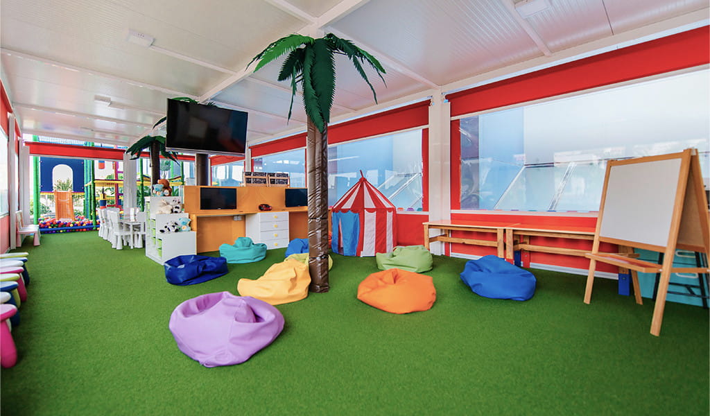 Sala de juegos infantiles con cojines de colores y una pizarra en Tenerife.
