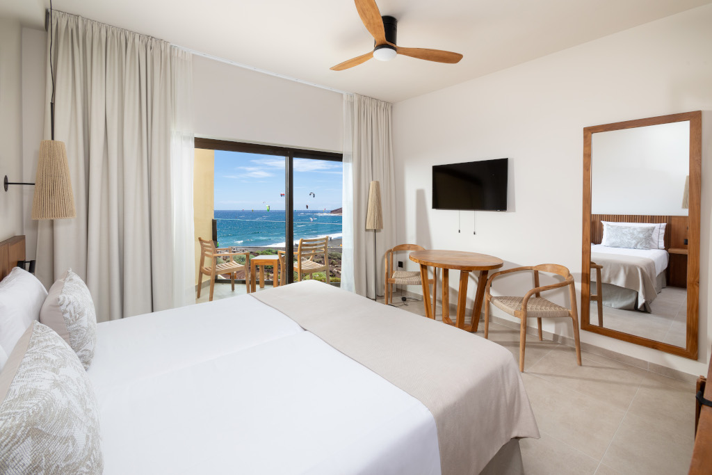 Habitación de hotel en Tenerife con vista al mar y decorada en tonos claros.