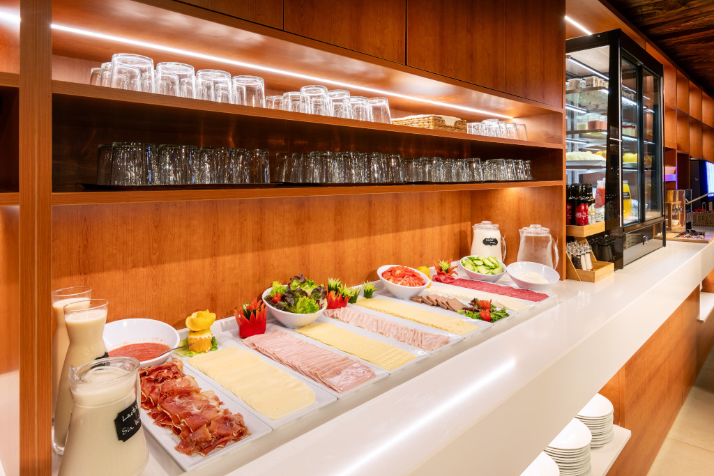 Buffet de desayuno con embutidos, quesos, verduras y bebidas en un hotel de Tenerife.