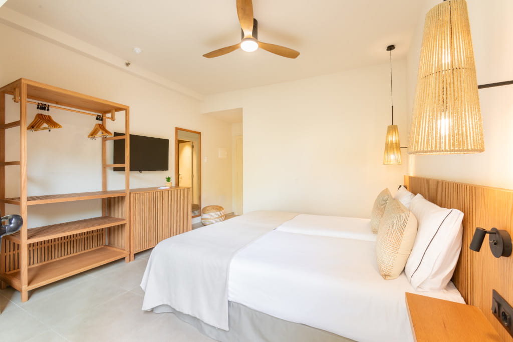 Habitación de hotel en Tenerife con cama doble, armario y televisor.