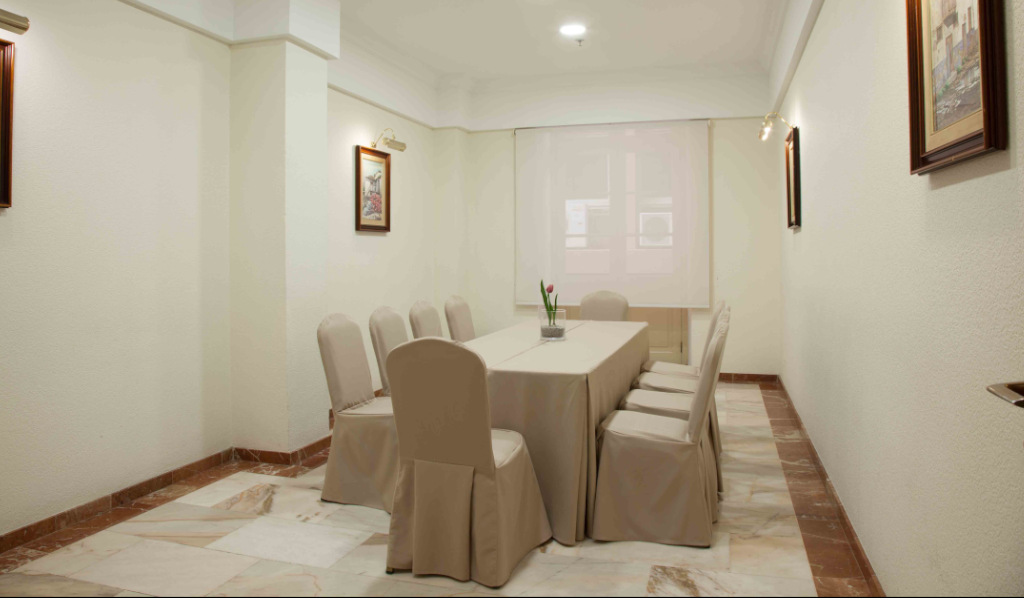 Sala de reuniones con mesa y sillas cubiertas, cuadro en la pared, en Santa Cruz de Tenerife.