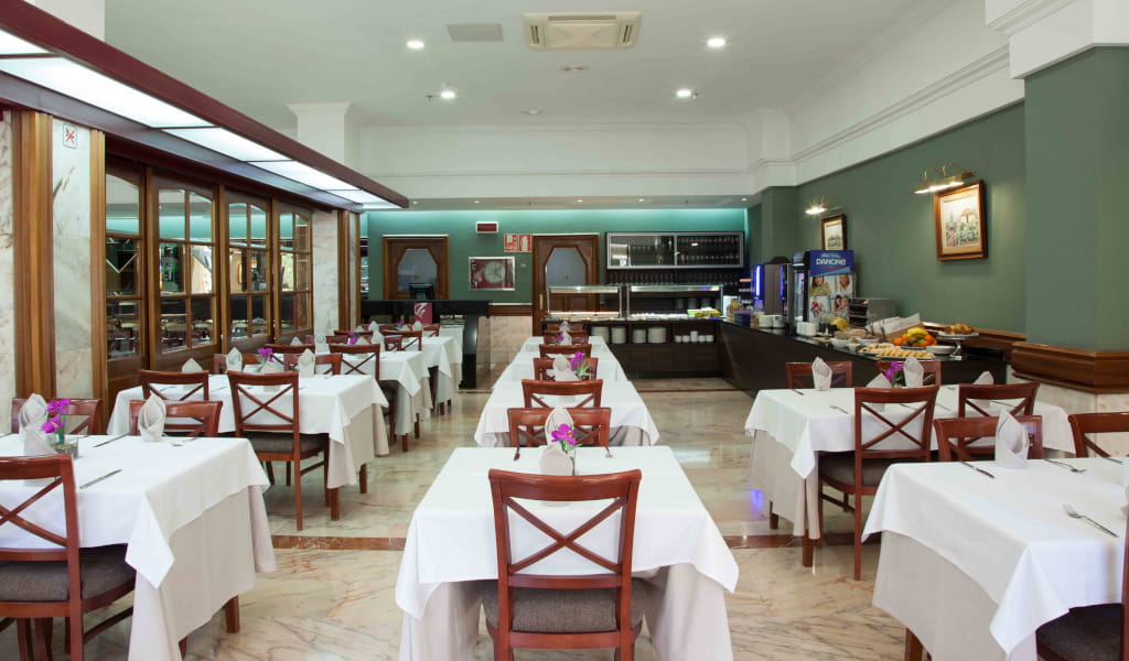 Restaurante en Tenerife con mesas vestidas y zona de buffet al fondo.