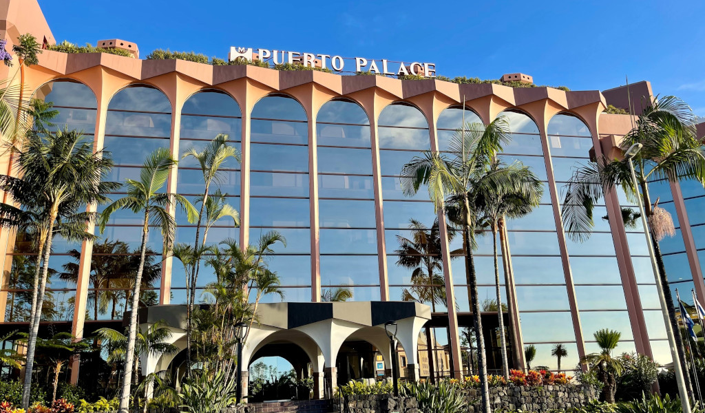 Fachada del Hotel Puerto Palace en Tenerife con palmeras al frente.