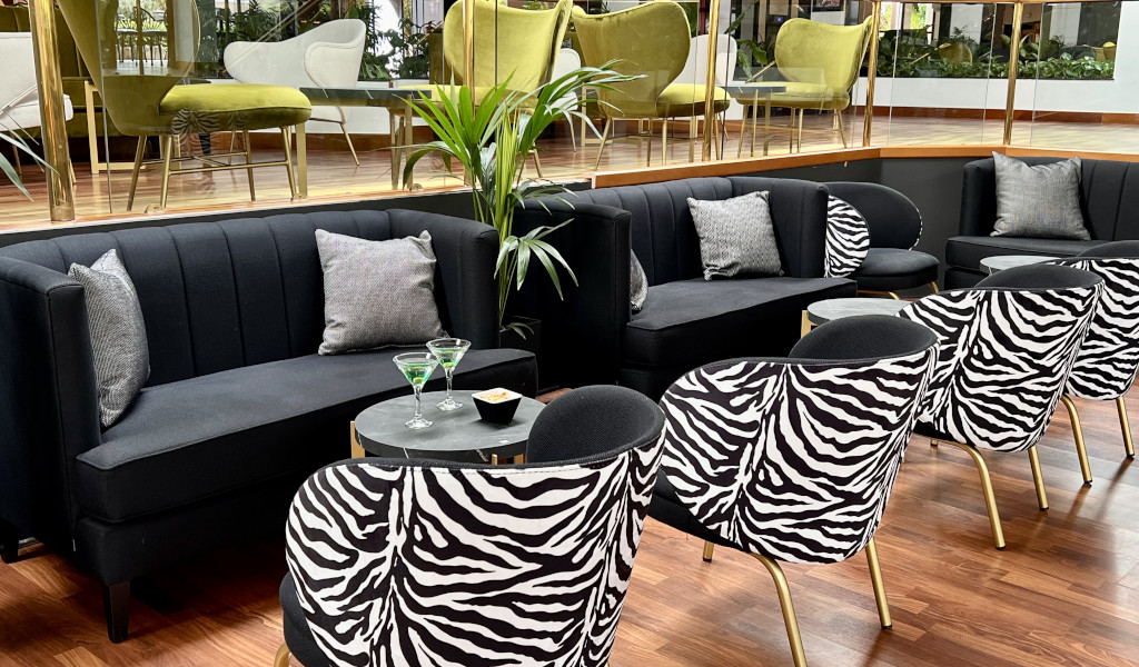 Sofás negros y sillas con estampado animal en lounge moderno en Tenerife.