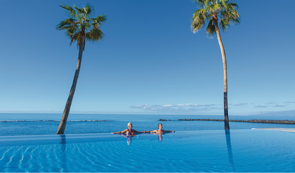 Persona disfrutando en una piscina infinita con vista al océano en Tenerife.