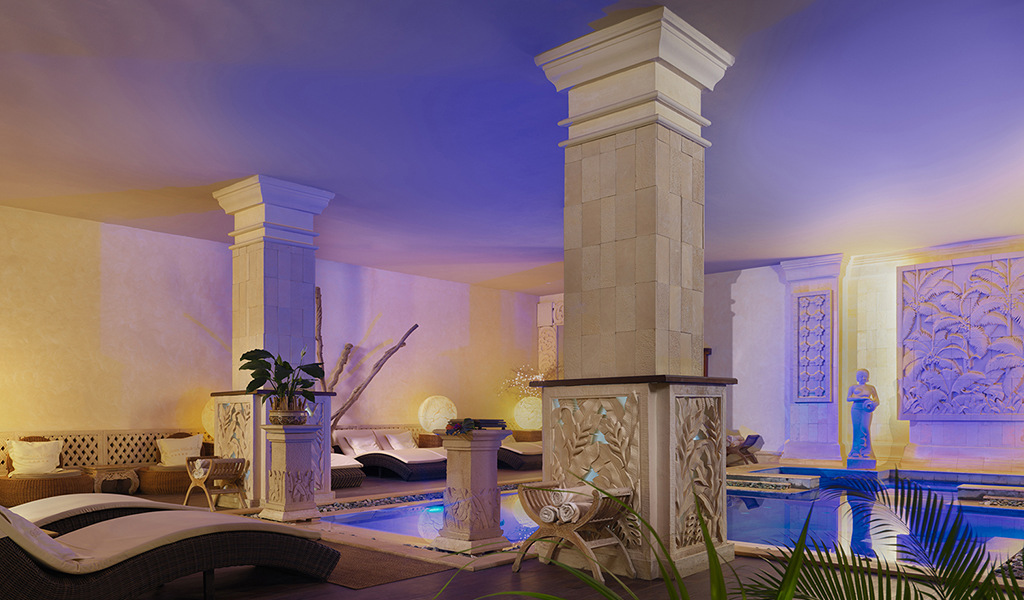 Área de descanso con columnas decorativas y piscina en un spa en Tenerife.