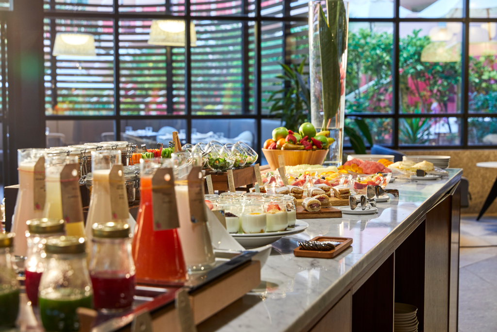 Mesa de desayuno buffet con jugos, yogures y fruta en un hotel de Tenerife.