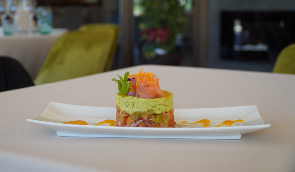 Plato de salmón y aguacate decorado con hierbas en restaurante de Tenerife.