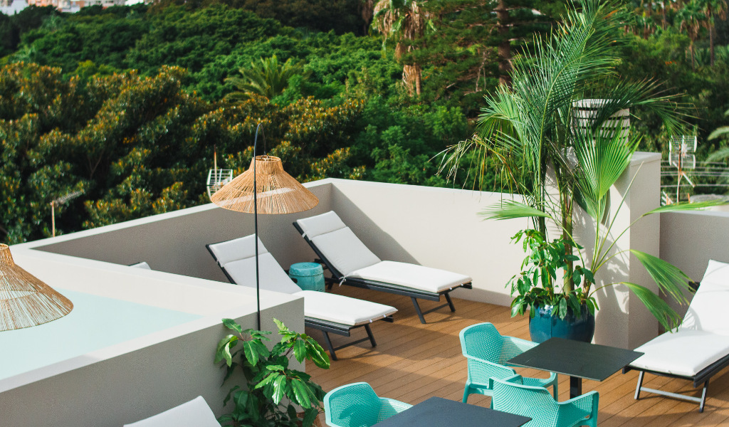 Terraza con tumbonas, sombrillas, sillas y plantas en Tenerife.