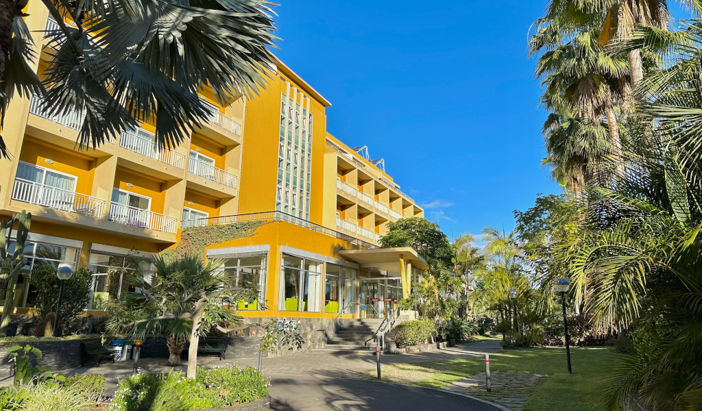 Edificio amarillo rodeado de palmeras en Puerto de la Cruz, Tenerife.