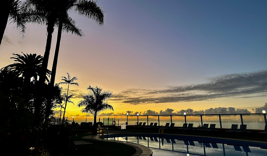 Atardecer sobre piscina y palmeras en Tenerife.