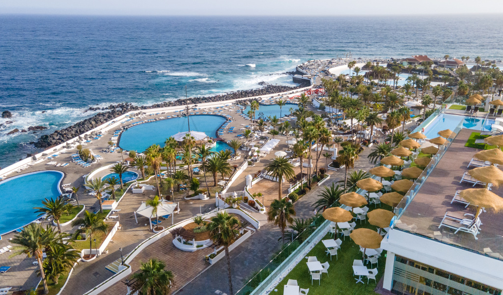 Piscinas rodeadas de palmeras con vistas al mar en Tenerife.