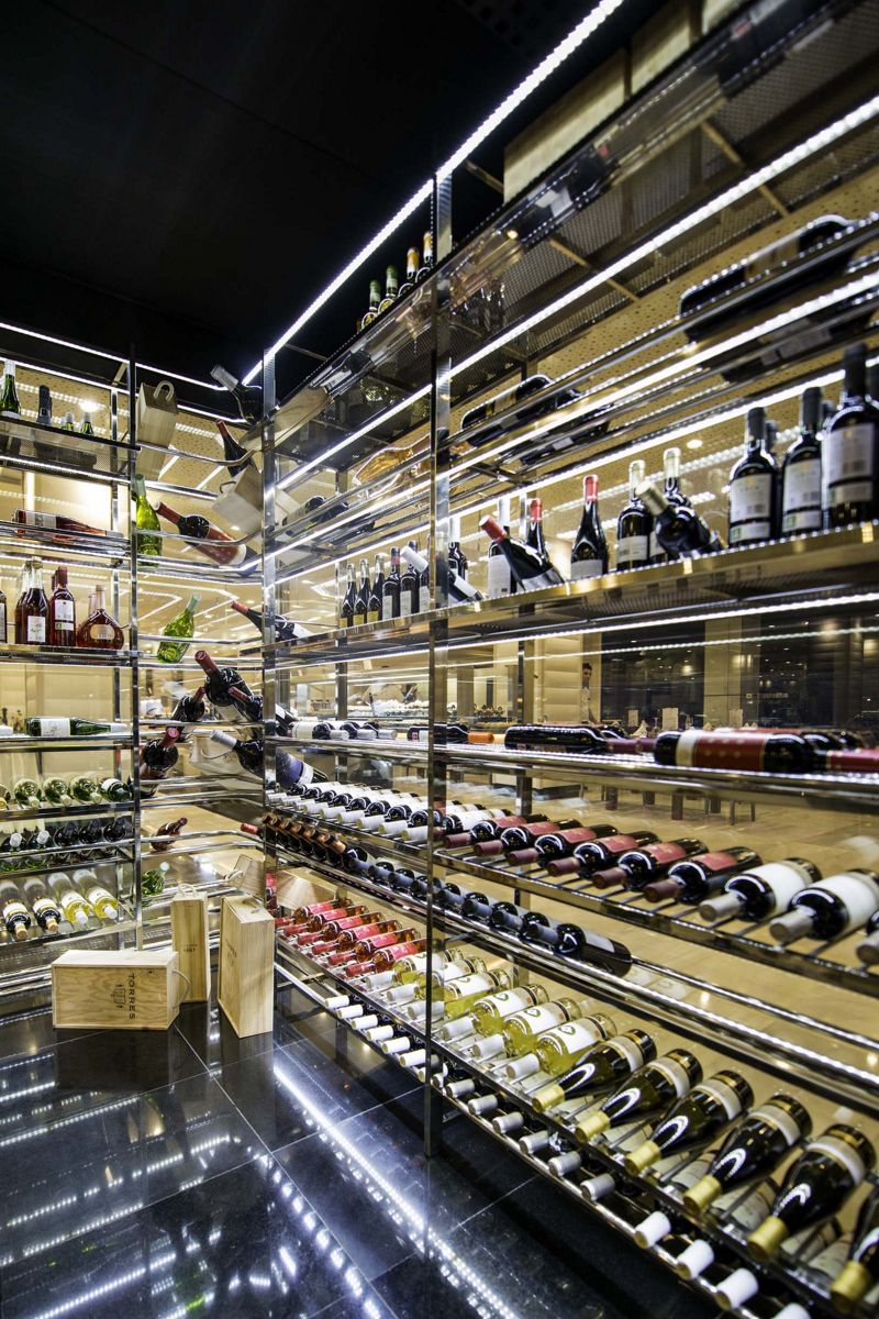 Botellas de vino organizadas en estantes de acero inoxidable en una vinoteca de Tenerife.
