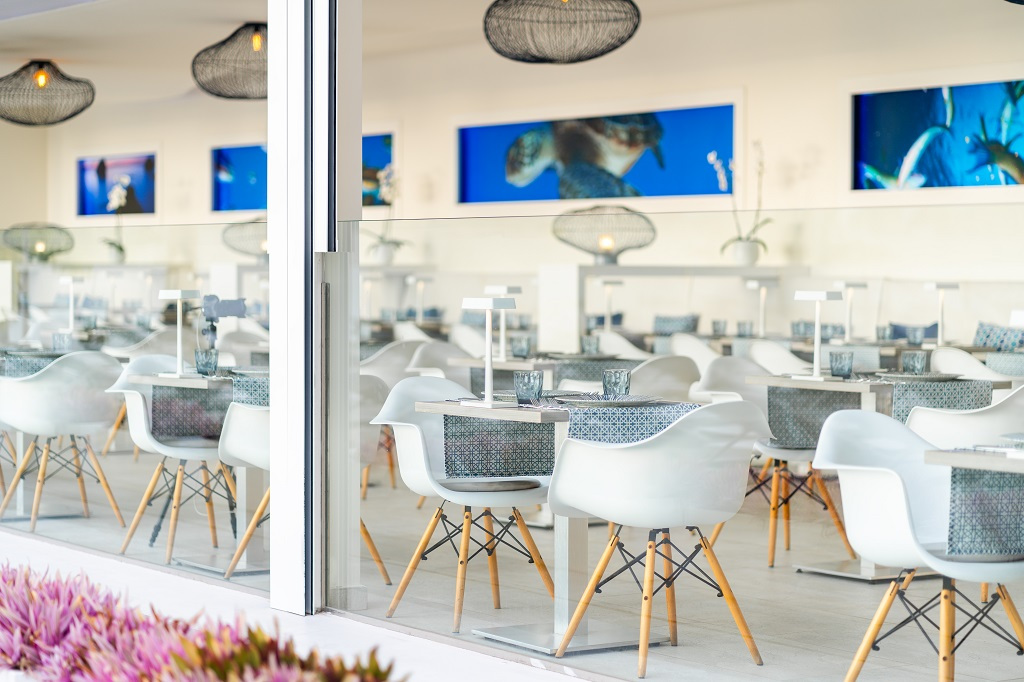Restaurante con decoración moderna en Tenerife y sillas blancas.
