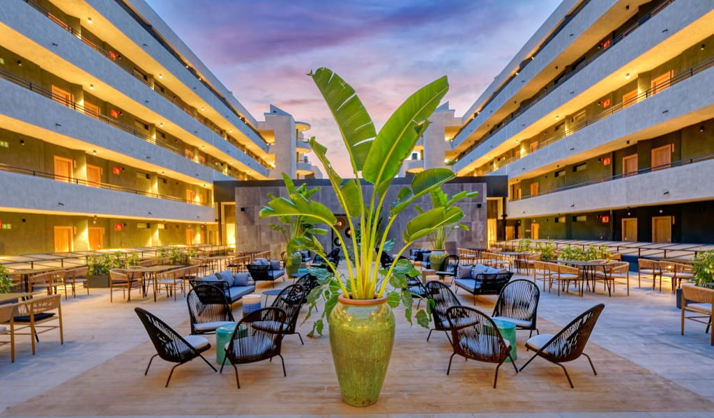 Patio al atardecer en un hotel de Tenerife con sillas y plantas.