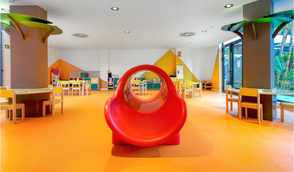 Sala de juegos infantil con tobogán rojo en un centro recreativo de Tenerife.