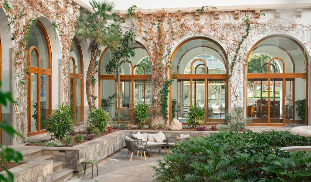 Patio con arcos, plantas y muebles al aire libre en Tenerife.