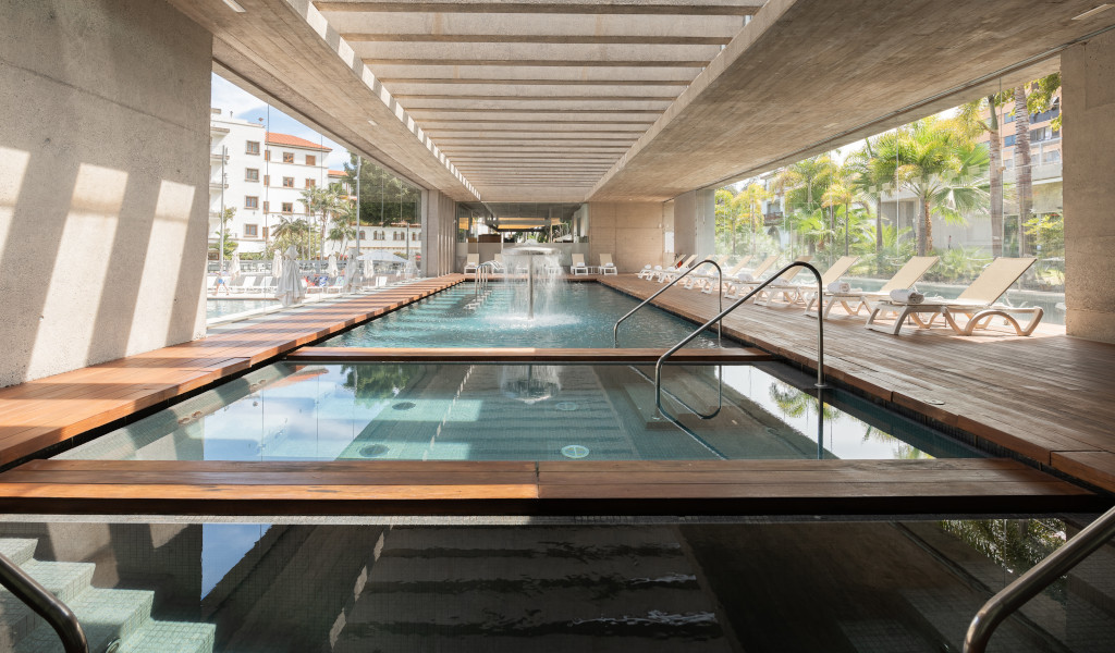 Piscina interior con tumbonas en un hotel de Tenerife.