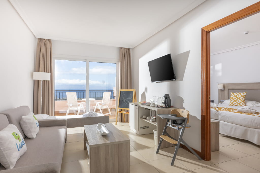 Sala de estar y dormitorio con vista al mar en hotel de Tenerife.