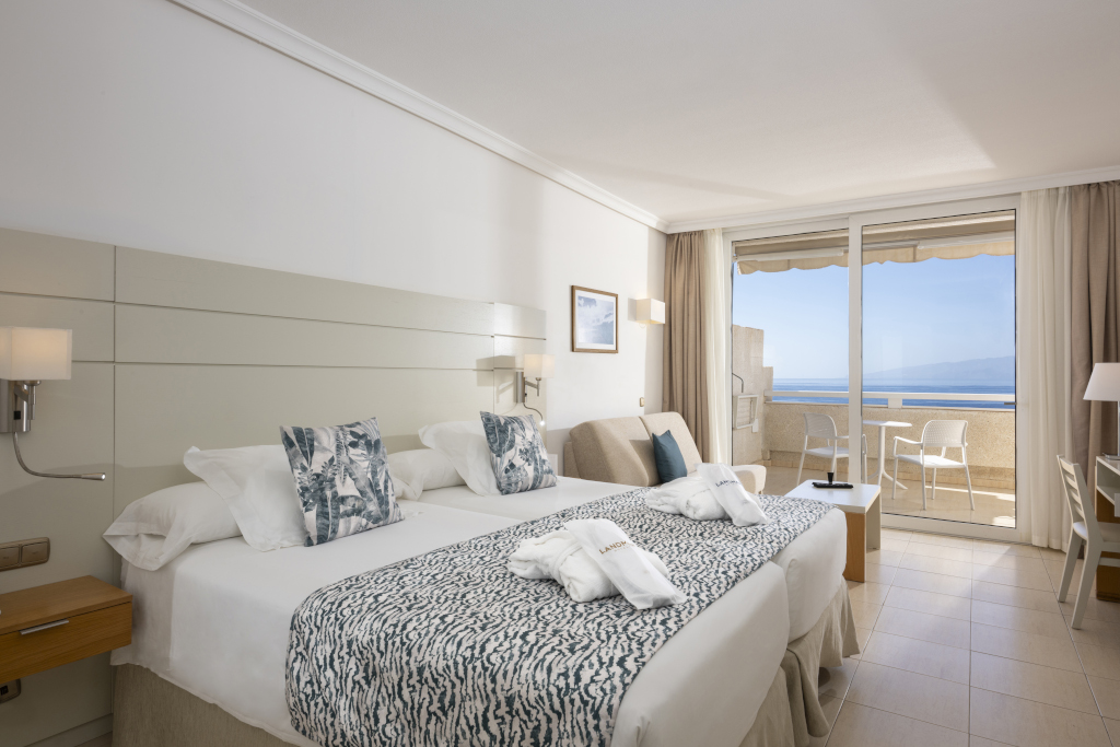 Habitación de hotel con vista al mar en Tenerife, con cama doble y balcón.