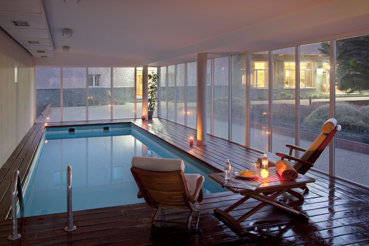 Piscina cubierta con tumbona y mesa en un spa de Tenerife.
