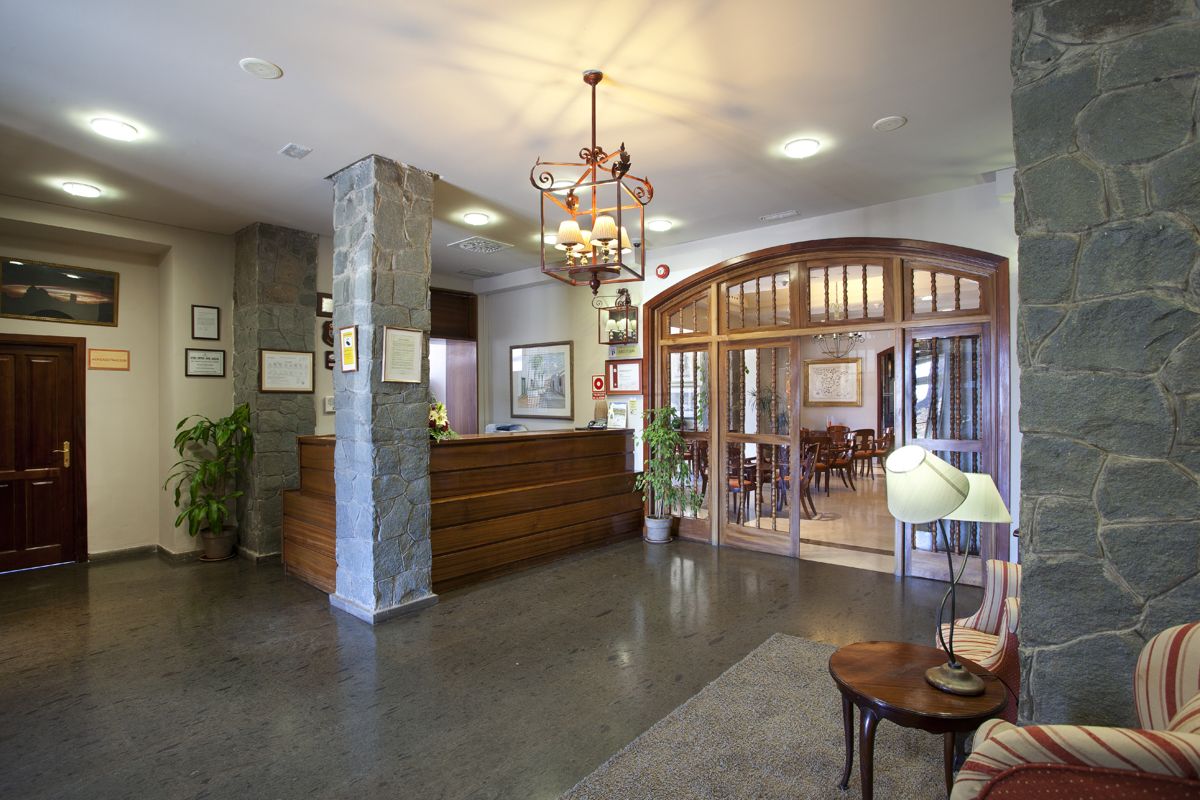 Recepción del hotel de piedra con lámpara y entrada al comedor en Tenerife.