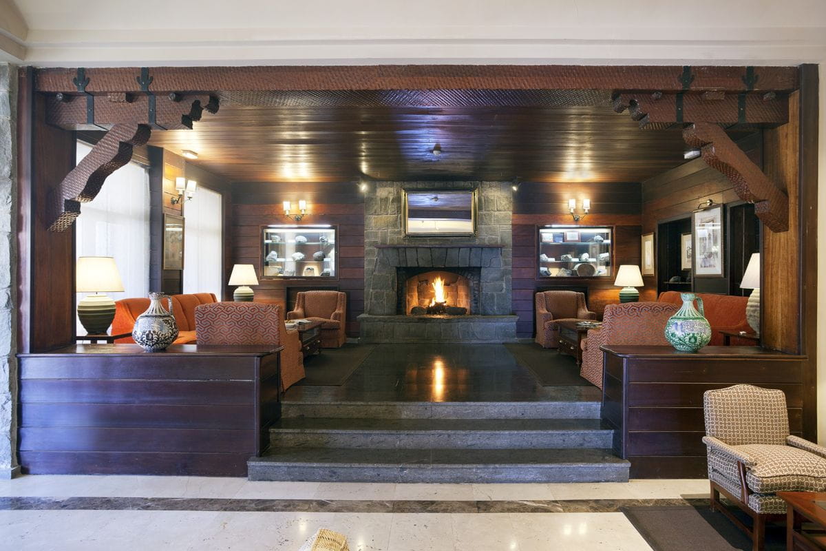 Sala de estar con chimenea y sofás en un hotel de Tenerife.