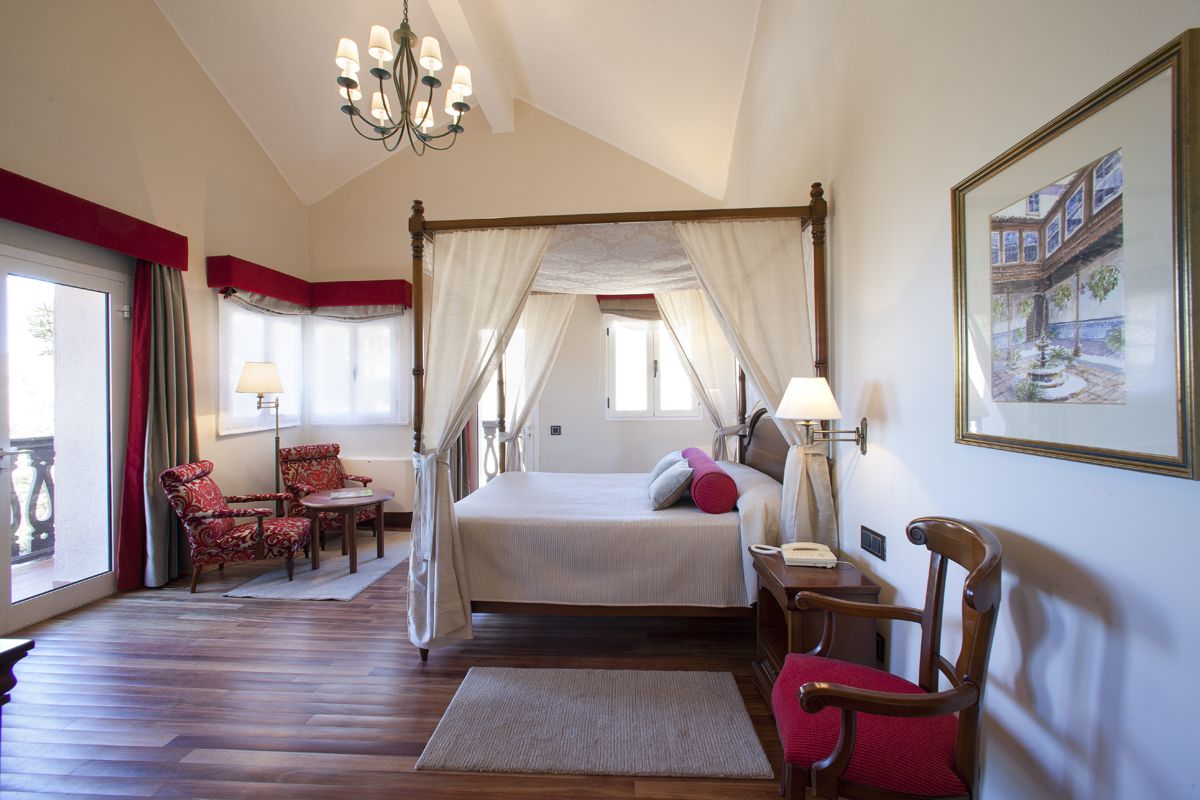 Habitación con cama con dosel, sillas y lámparas en Tenerife.