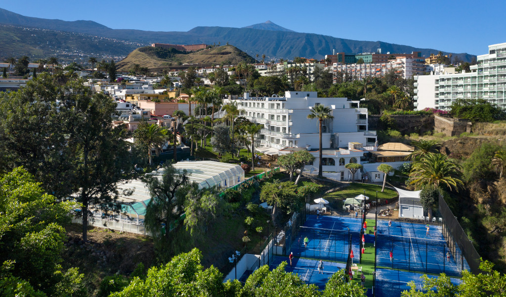 Vista aérea de canchas de pádel en Puerto de la Cruz, Tenerife, con edificios de fondo.