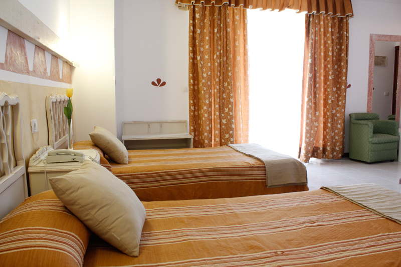 Habitación con dos camas individuales y cortinas anaranjadas en un hotel de Tenerife.
