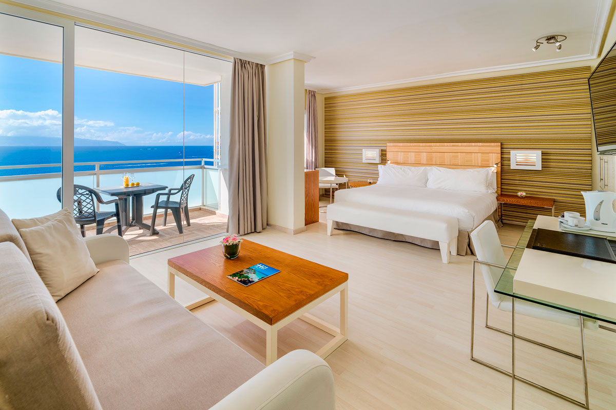 Habitación luminosa con cama grande y balcón con vista al mar en Tenerife.