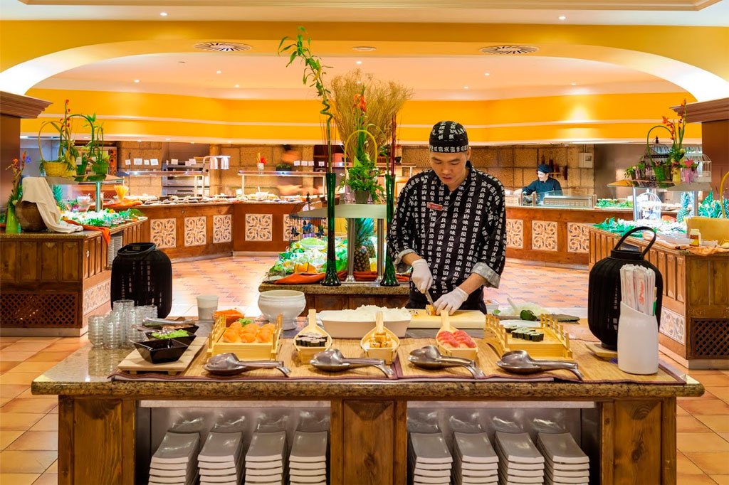 Chef prepara sushi en restaurante buffet en Tenerife.
