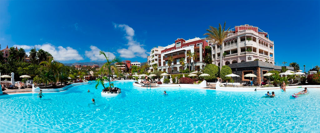 Piscina en hotel de lujo en Tenerife con adultos y niños nadando.