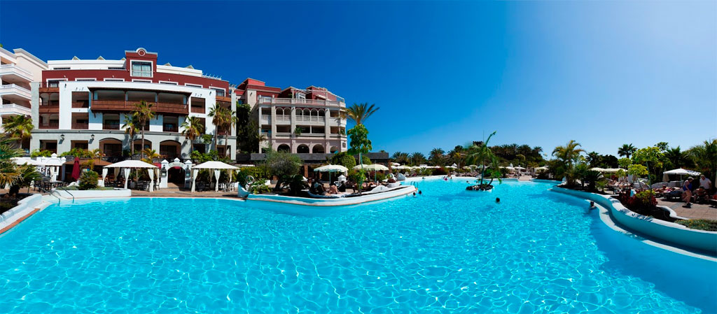 Piscina del hotel con edificio de varios pisos en Costa Adeje, Tenerife.