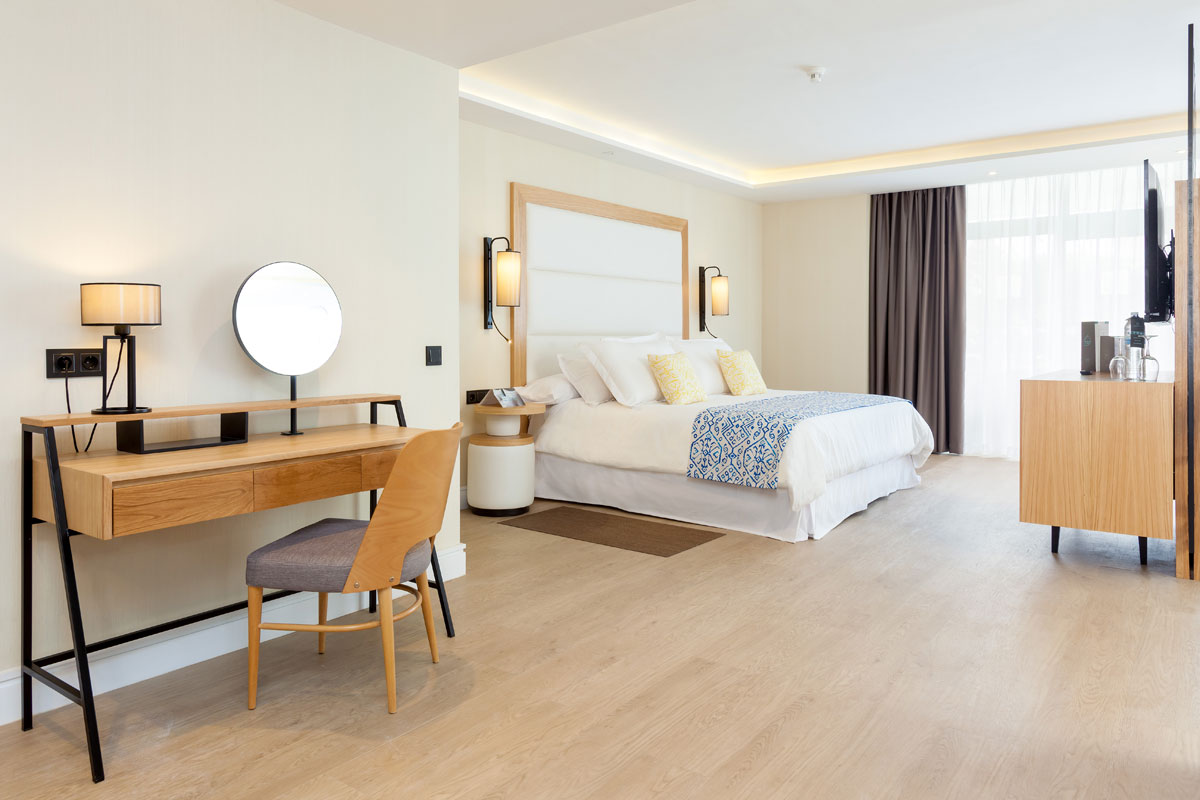 Habitación de hotel moderna en Tenerife con cama grande y escritorio de madera.