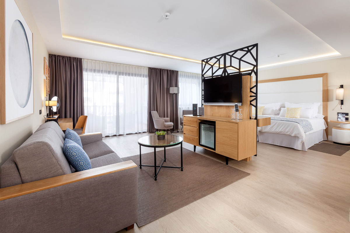 Habitación de hotel moderna con sala de estar y cama en Tenerife.
