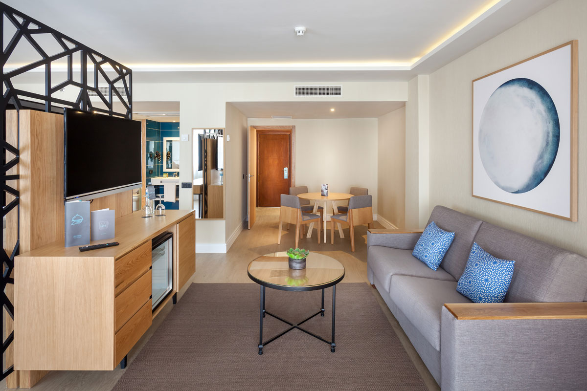 Sala de estar moderna en un hotel de Tenerife con sofá, mesa y televisor.