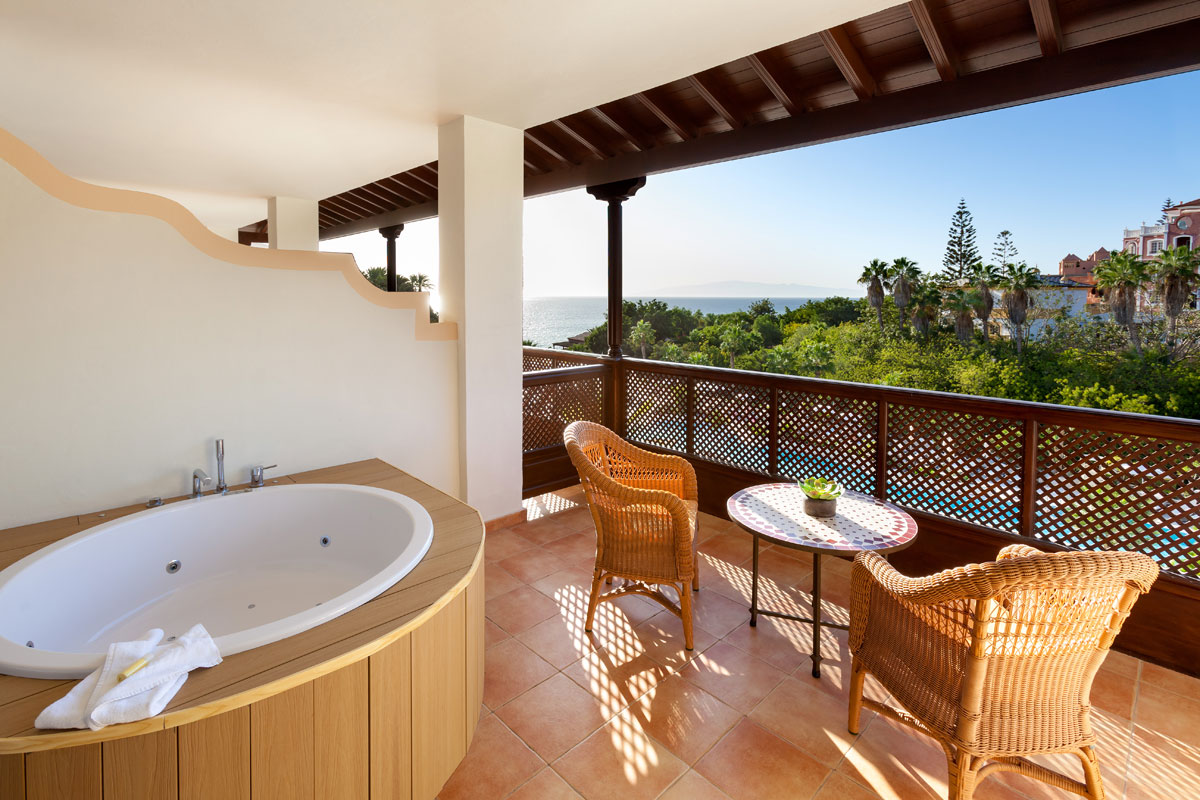 Bañera en terraza con vistas al mar y jardín en un hotel en Tenerife.