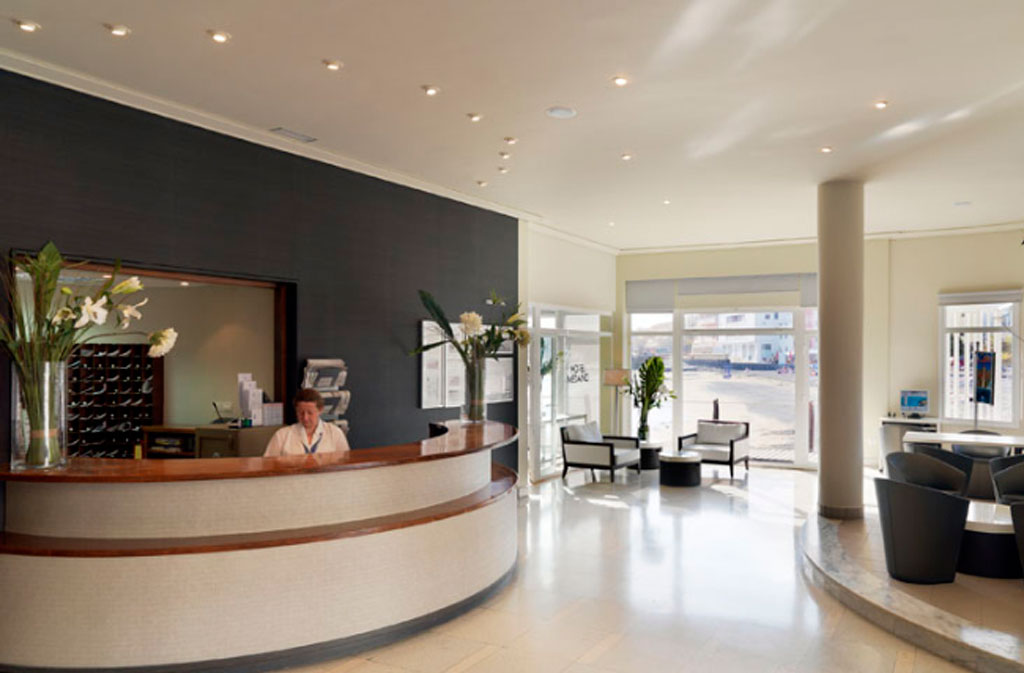 Recepción de hotel en Tenerife con mobiliario moderno y flores.