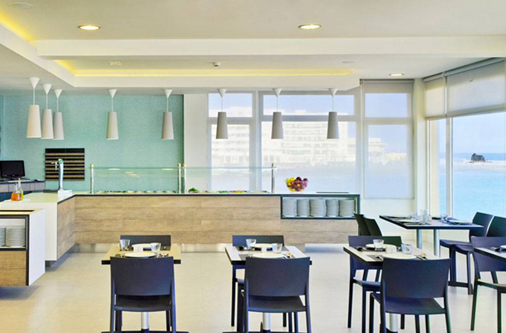 Restaurante luminoso con mesas preparadas y vista al mar en Tenerife.