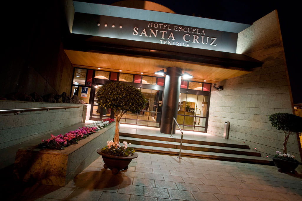 Entrada del Hotel Escuela Santa Cruz en Tenerife iluminada de noche.