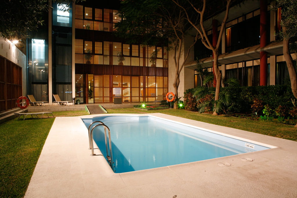 Piscina iluminada junto a un edificio en Santa Cruz de Tenerife.