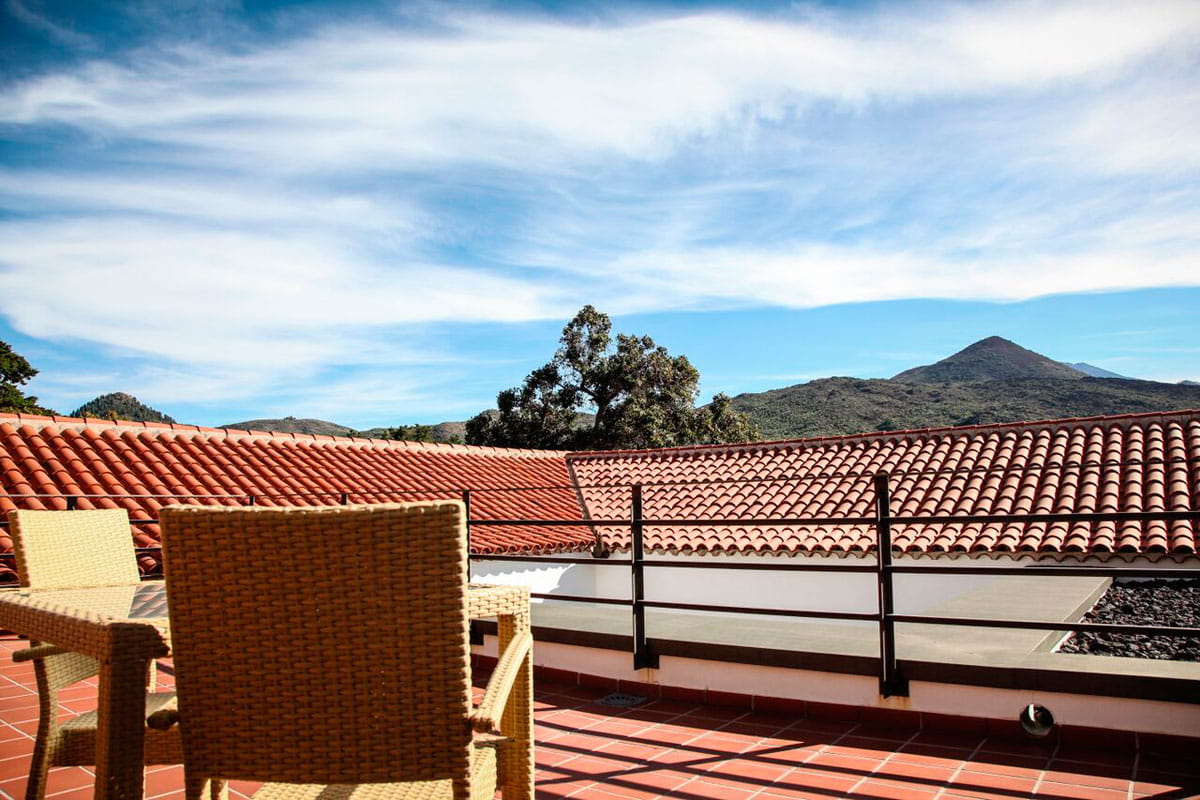 Terraza con sillas y vistas a montañas en Tenerife bajo cielo azul.