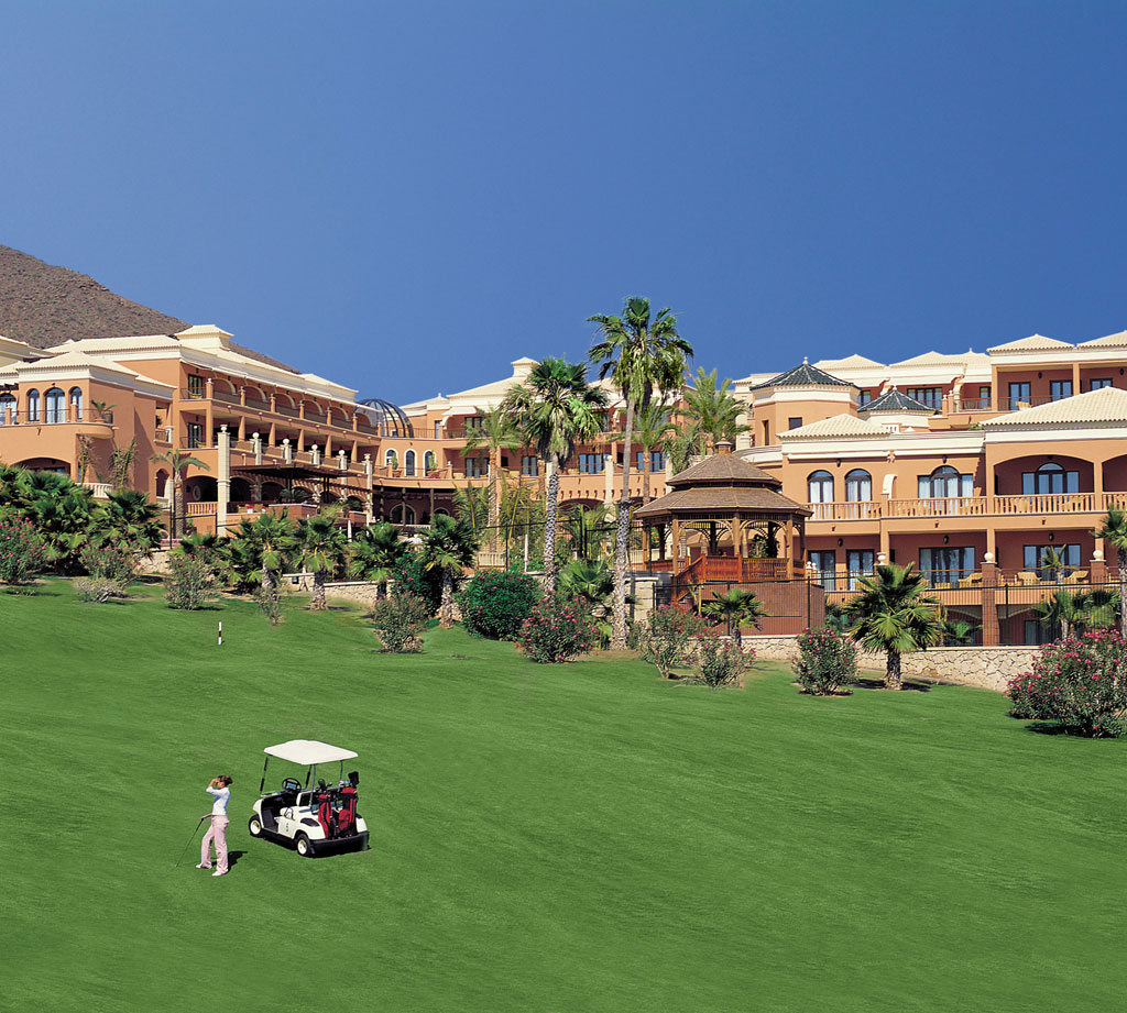 Edificio con golfista y carrito en jardín, Tenerife.