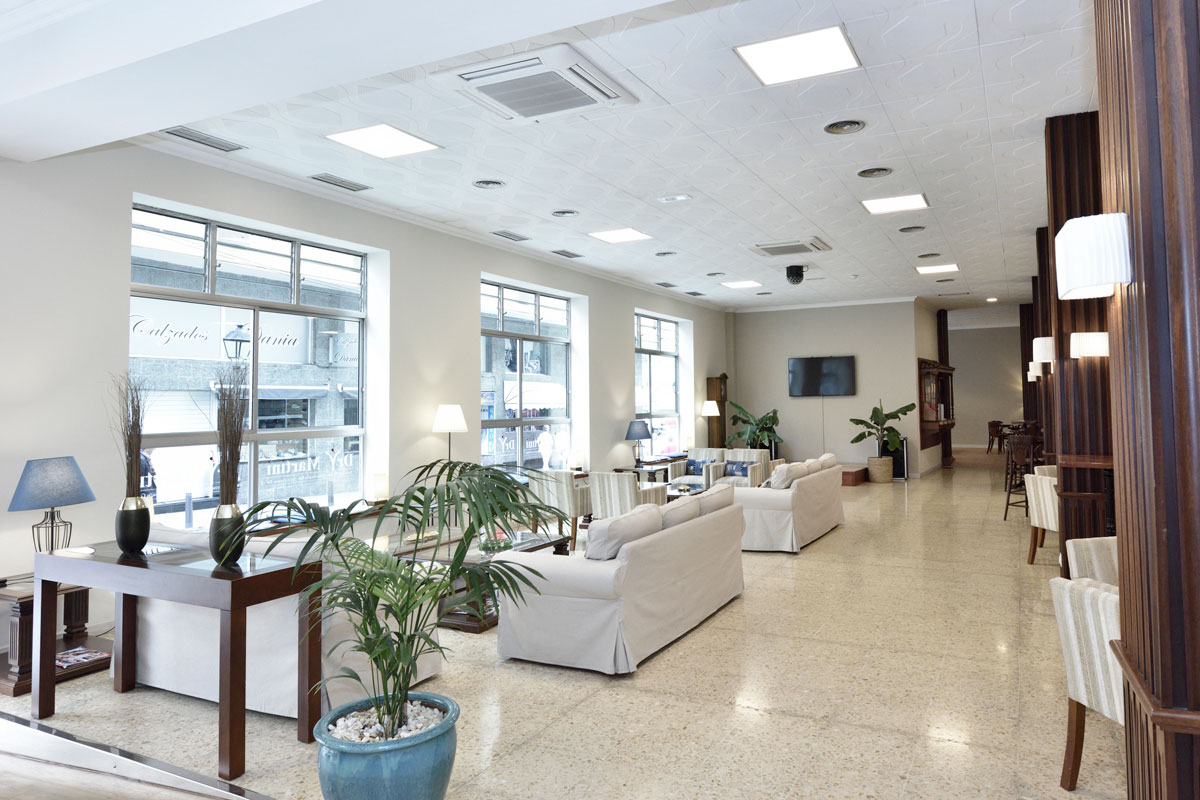 Lobby con sofás y plantas en Santa Cruz de Tenerife. Ventanales al fondo.